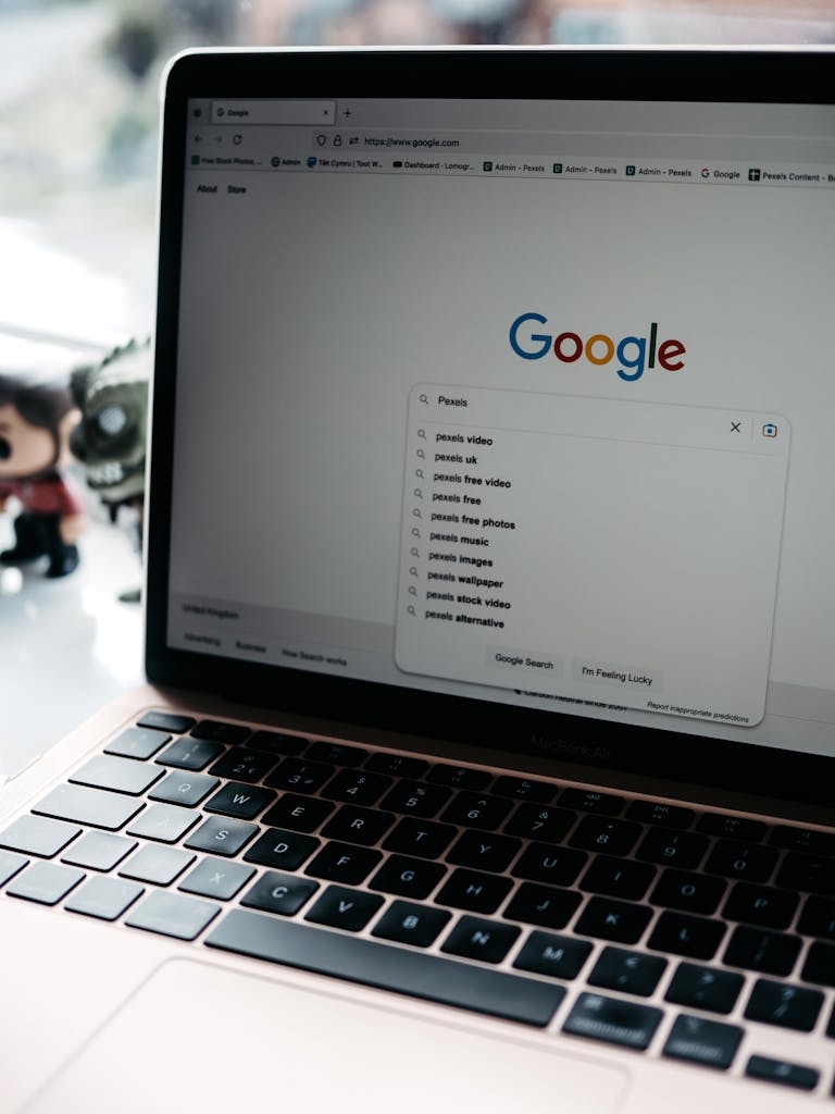 A close-up shot of a laptop displaying a Google search page with related searches visible. Posicionamiento web en Madrid