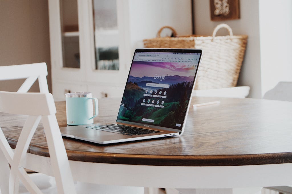 SEO para Abogados A sleek laptop on a wooden table with a mug, exemplifying a modern home workspace. 