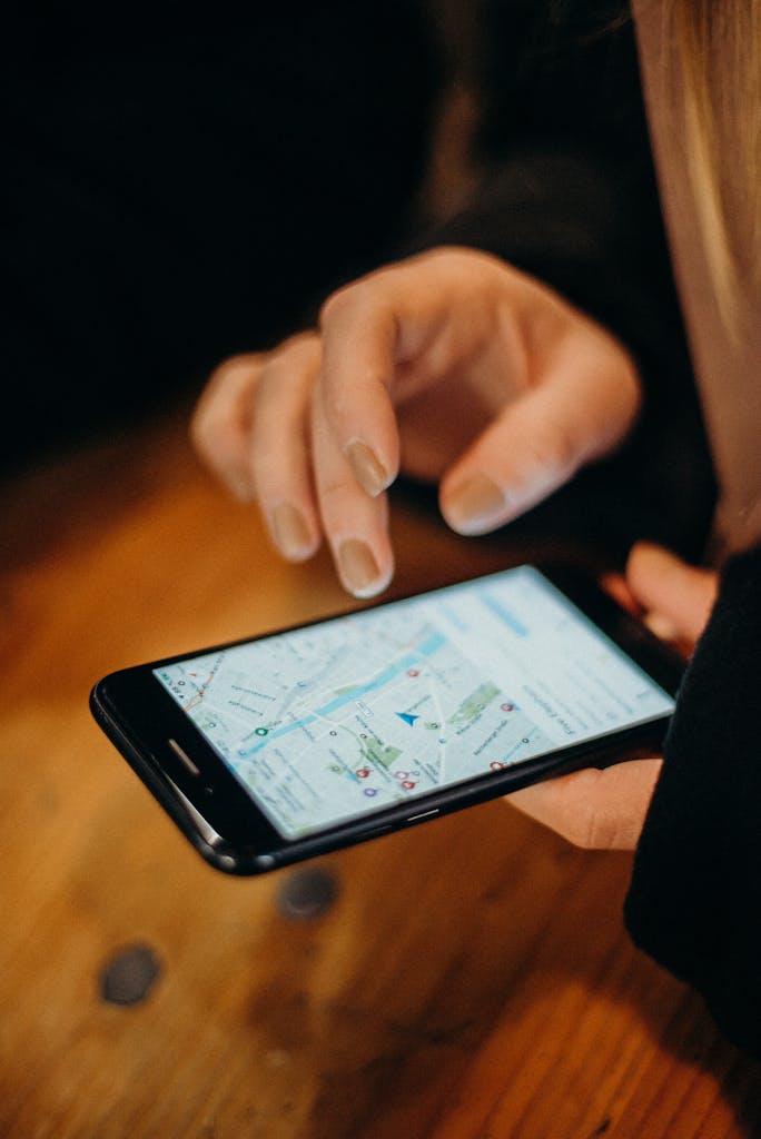 Close-up of a hand using a smartphone displaying a map for navigation.