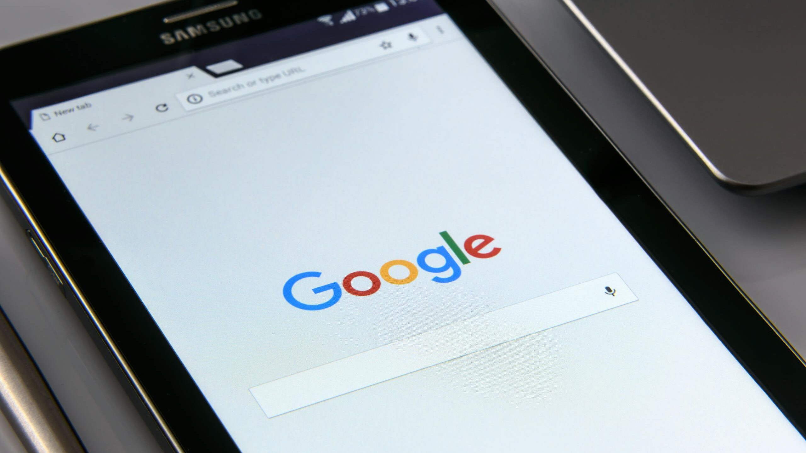 Close-up of a tablet displaying Google's search screen, emphasizing technology and internet browsing.